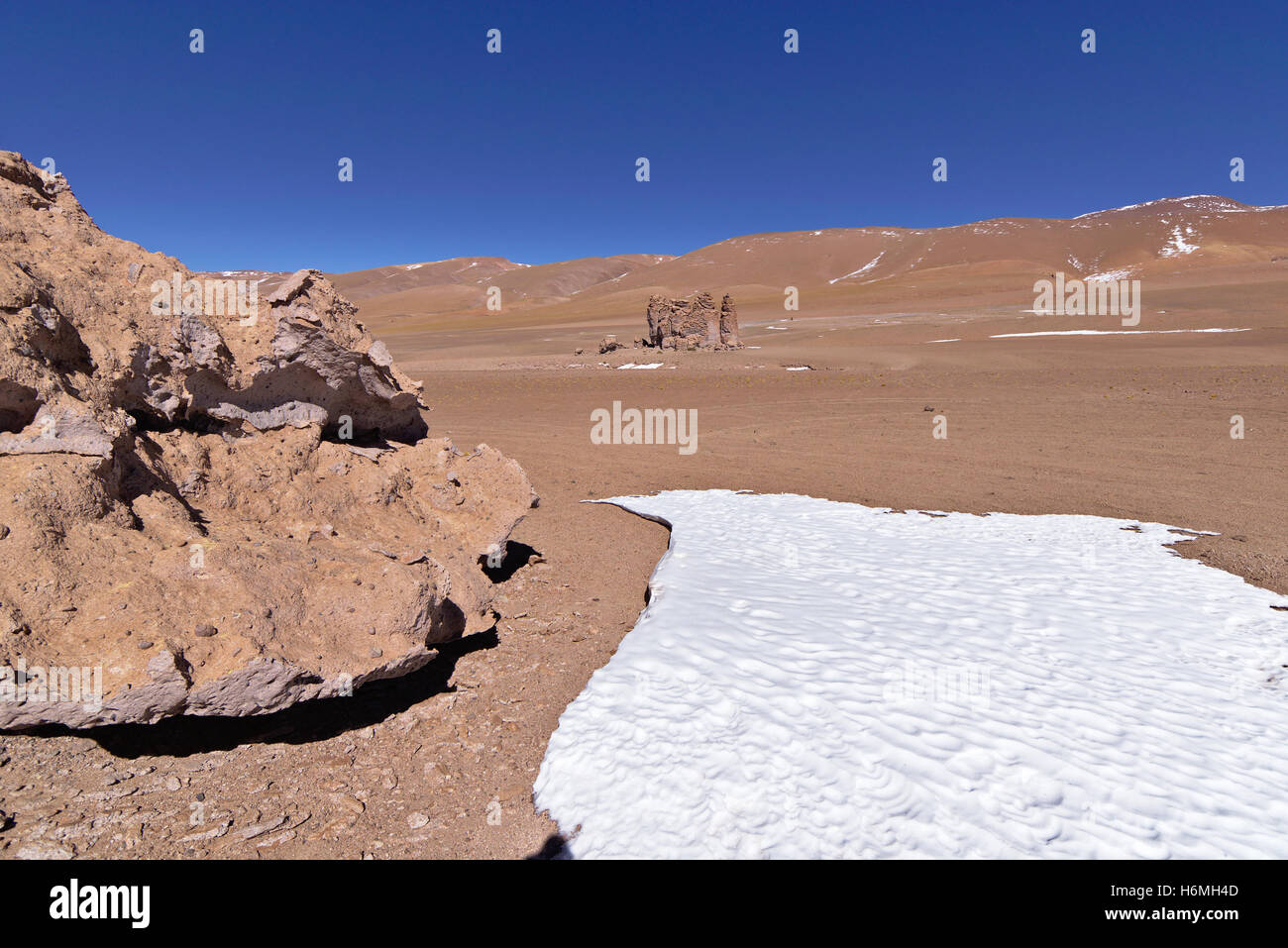 Erosion geformte Felsen in der Wüste neben einem Eisblock. Stockfoto