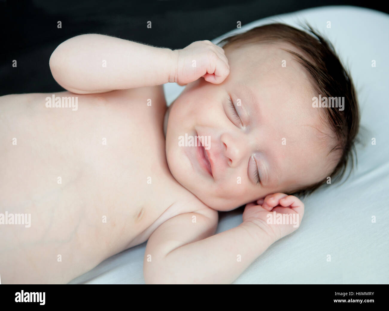 Zarte Baby Lächeln beim Nickerchen in der Krippe Stockfoto