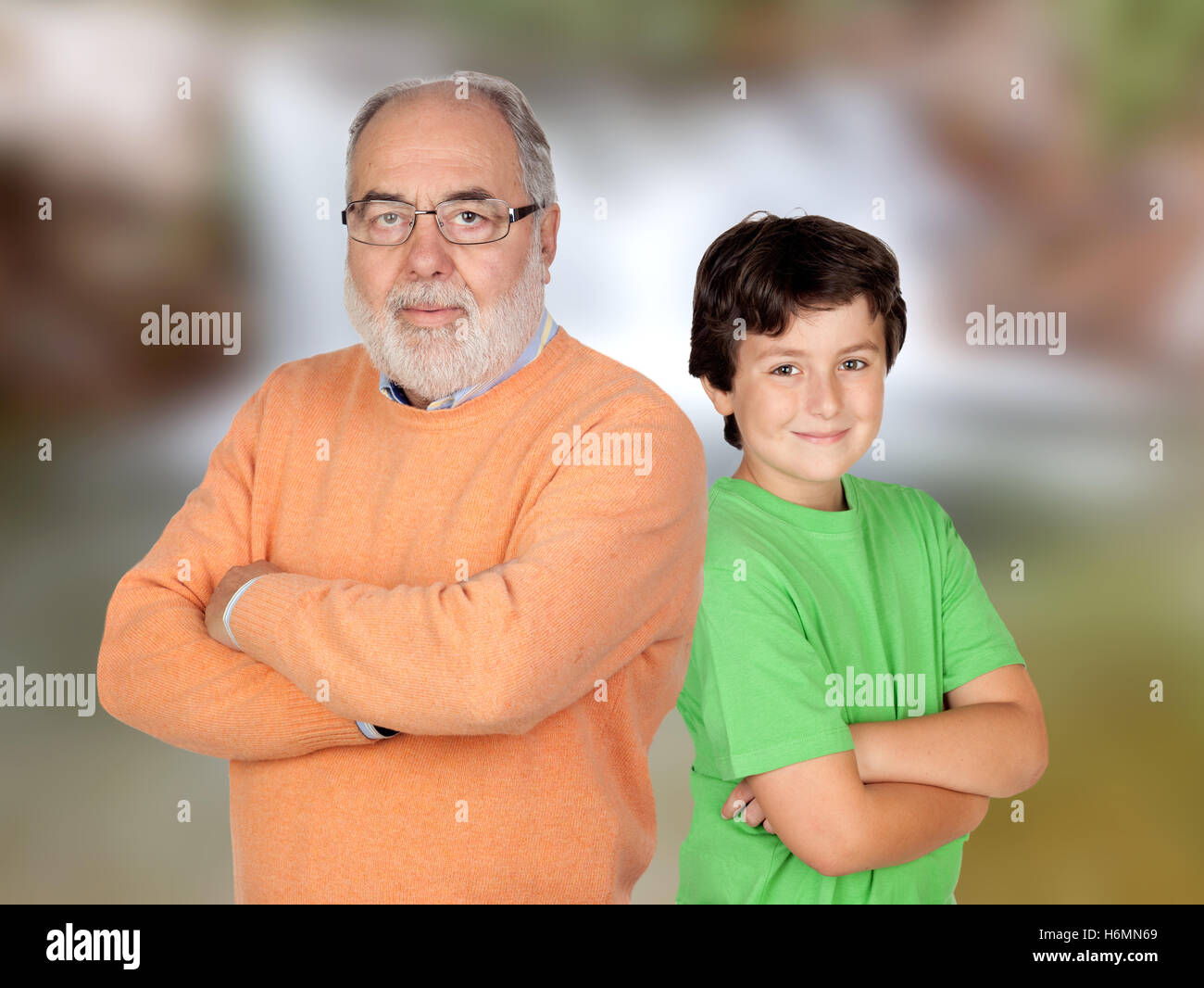 Zwei Generationen, Großvater und Enkel mit verschränkten Armen und unscharfen Hintergrund Stockfoto