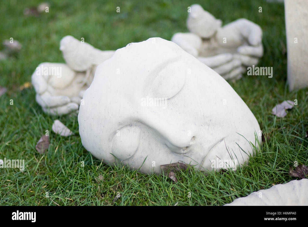 Gebrochenen Stein Maske auf dem Rasen Stockfoto