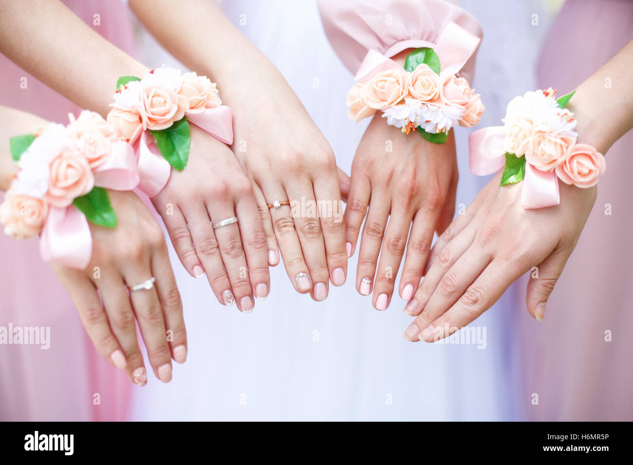 Braut und Brautjungfern mit Blume Armbänder auf Händen. Closeup Stockfoto