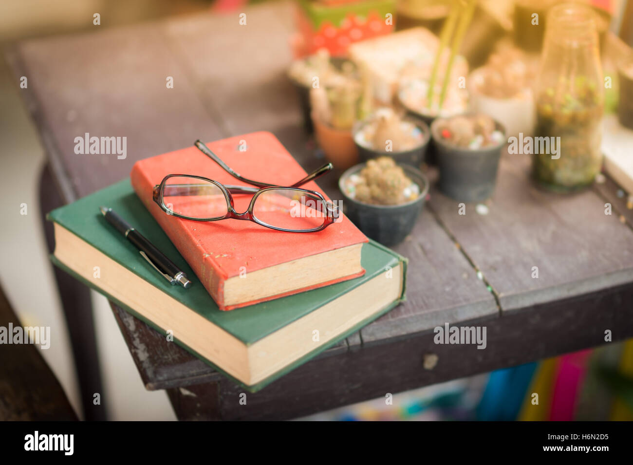 Gläser mit Büchern und Stift auf Holztisch in Morgen Zeit. Wochenende-Lifestyle-Konzept Stockfoto