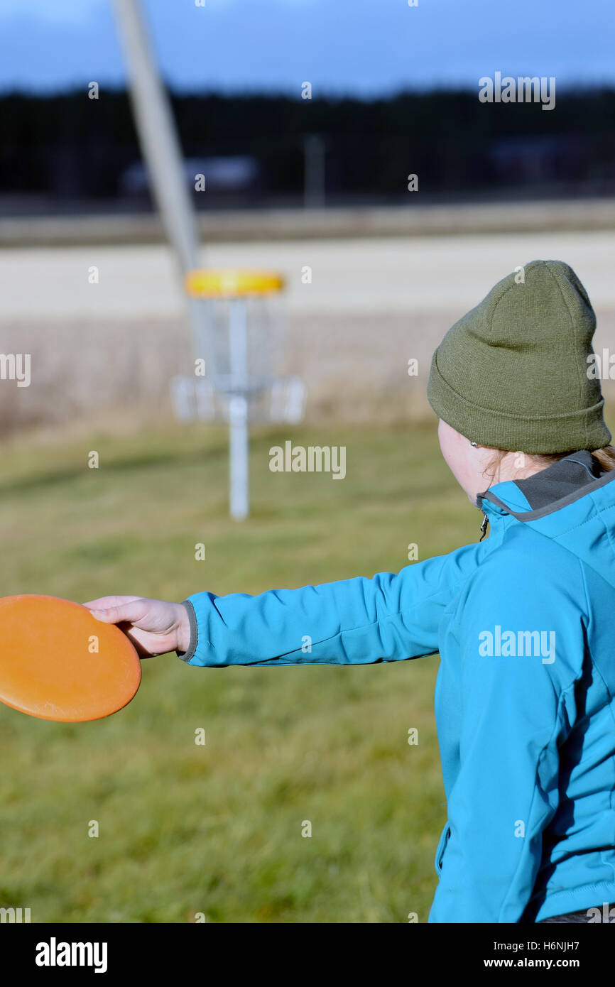 Junge Frau mit dem Ziel Scheibe auf Disc-Golf-Kurs. Person zu konzentrieren. Stockfoto