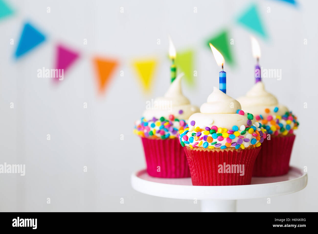 Bunte Geburtstag Cupcakes auf eine Kuchenplatte Stockfoto