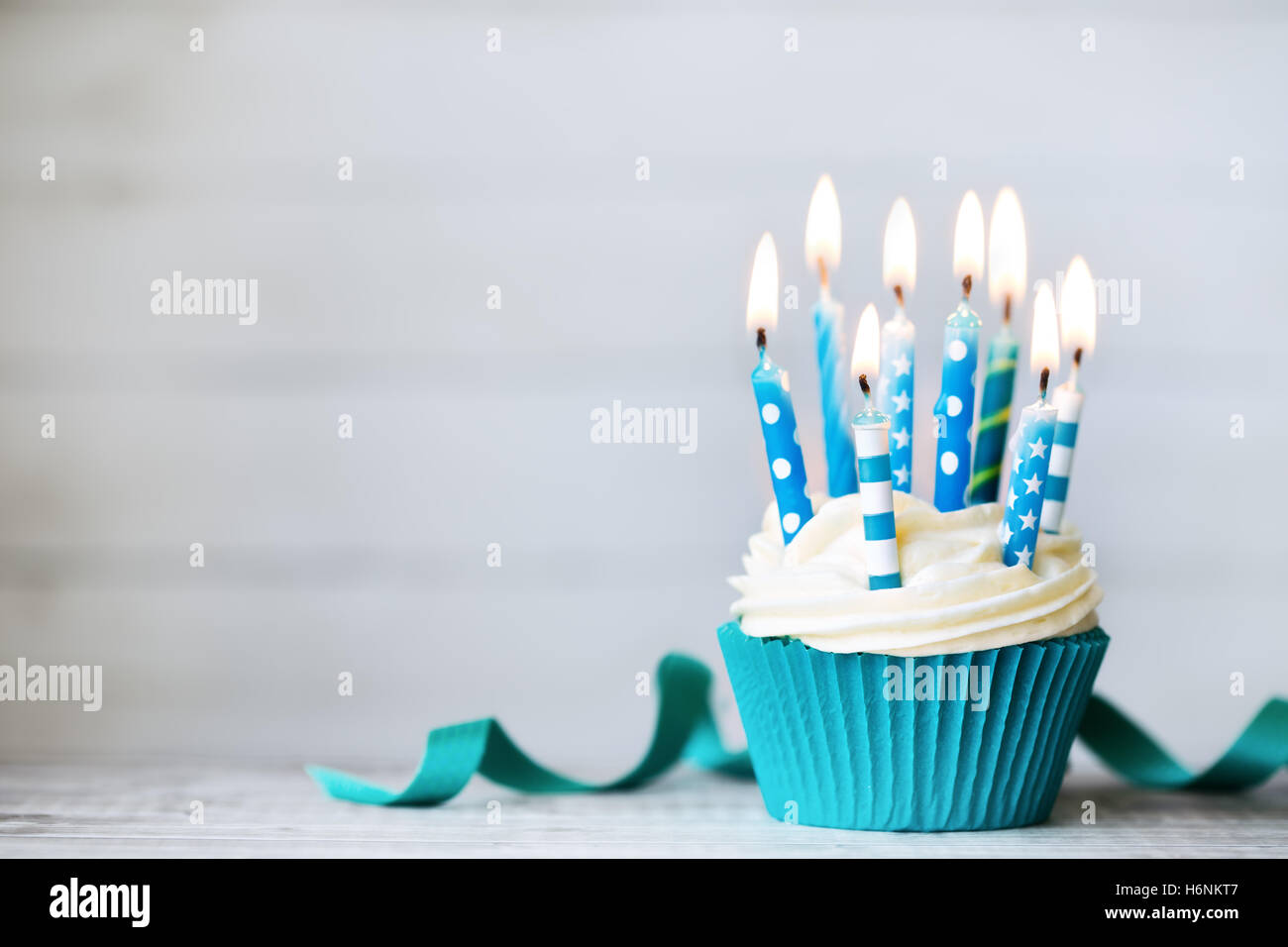 Cupcake mit blauen Geburtstagskerzen Stockfoto