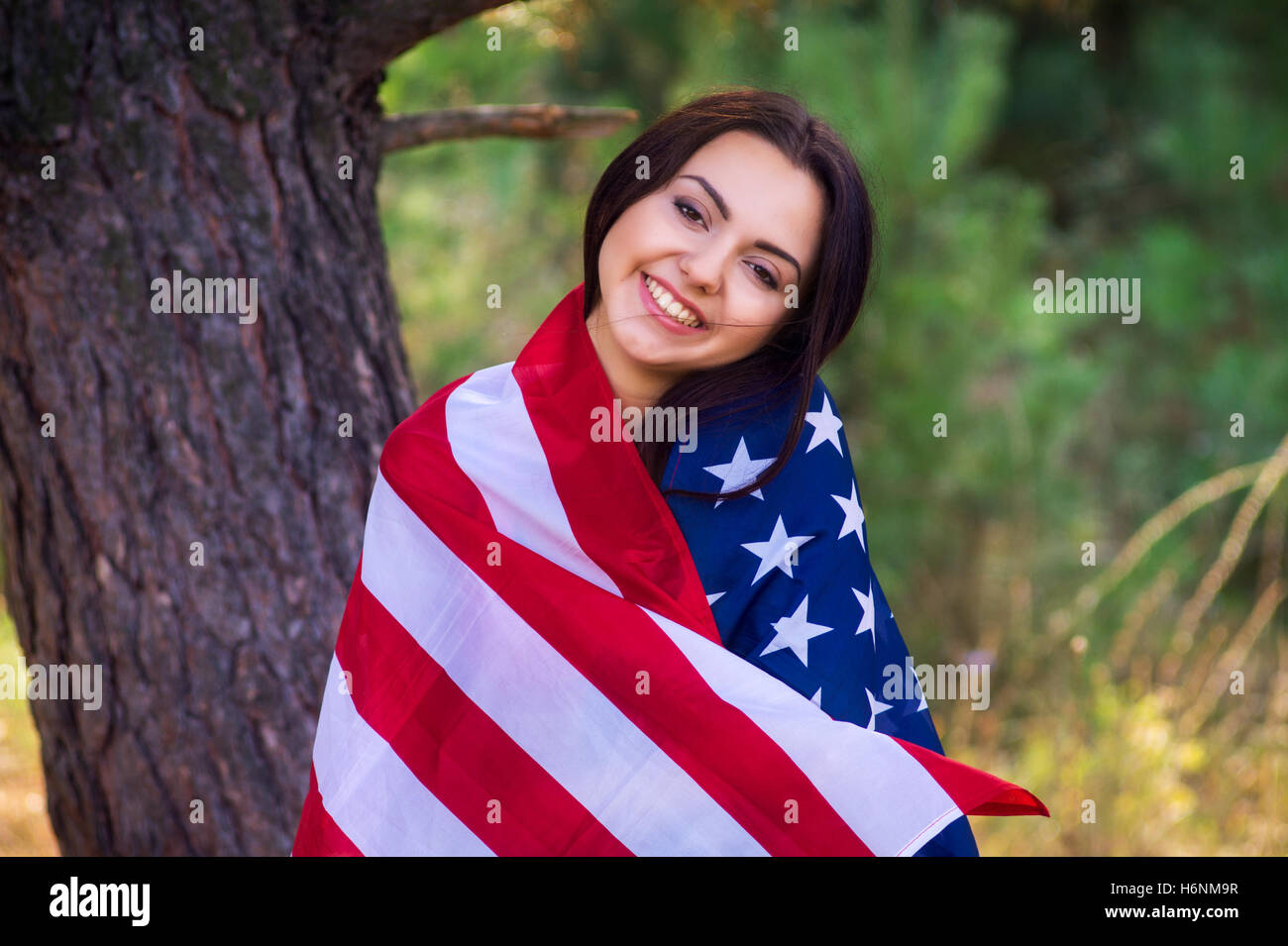 Schönes Model posiert mit der Flagge der Vereinigten Staaten in der Sommerpark Stockfoto