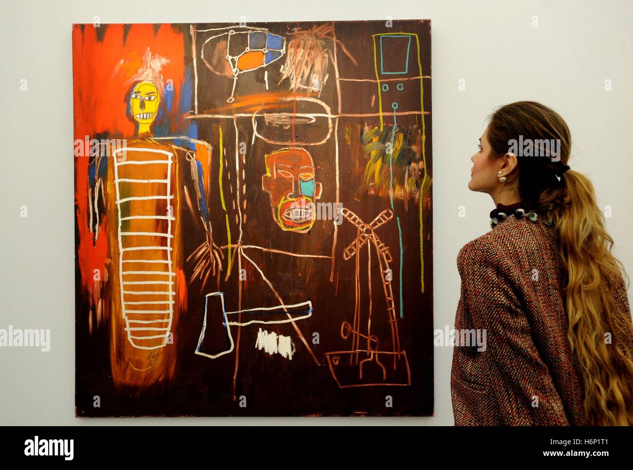 Eine Frau betrachtet das Gemälde von Jean-Michel Basquiat mit dem Titel Air Power' 1984 während der Pressevorschau der persönlichen Sammlung von David Bowie, bevor es von SothebyÂ in London verkauft wird. Stockfoto