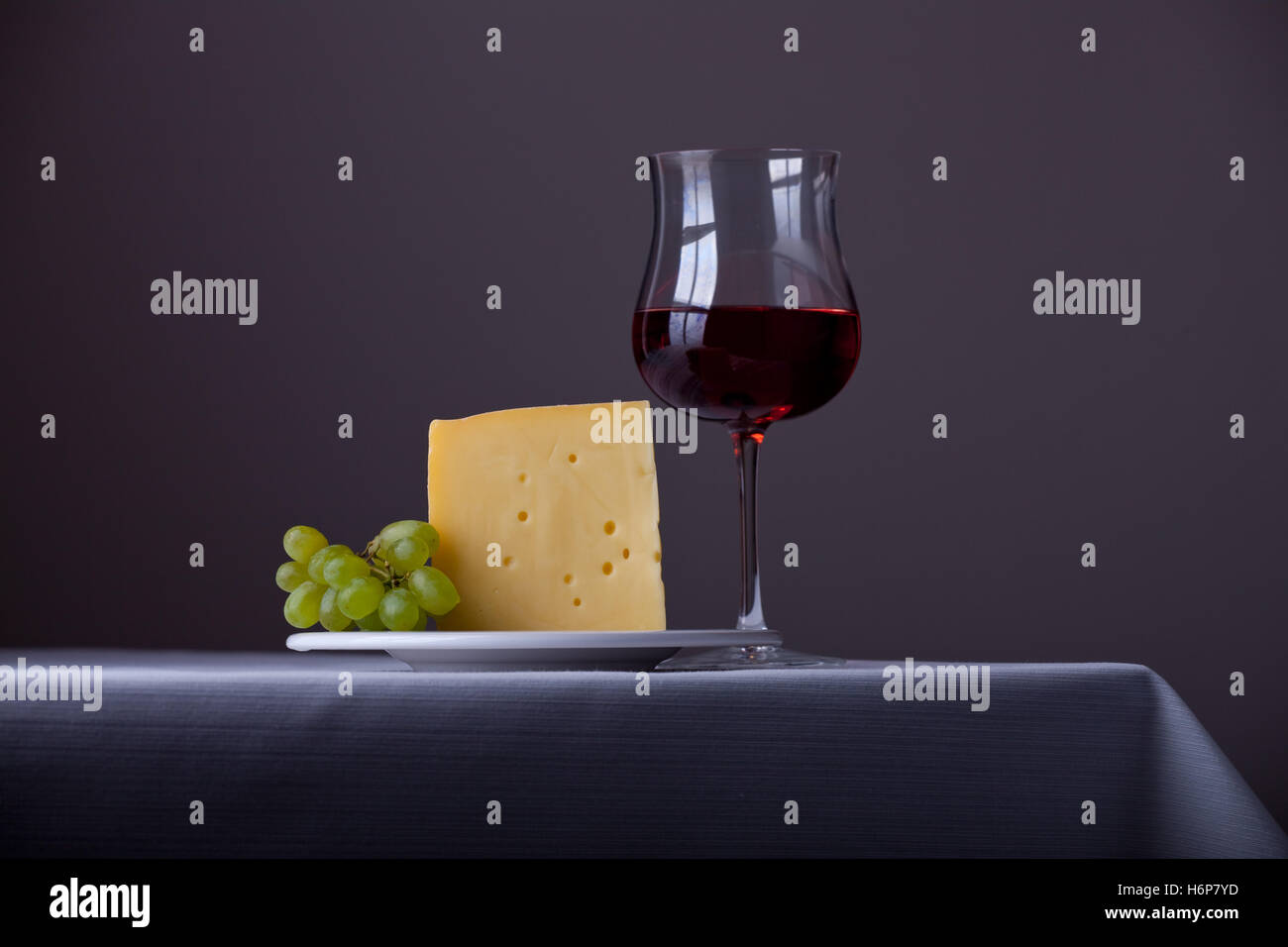 Stück Käse, ein paar Weintrauben und Rotwein Stockfoto