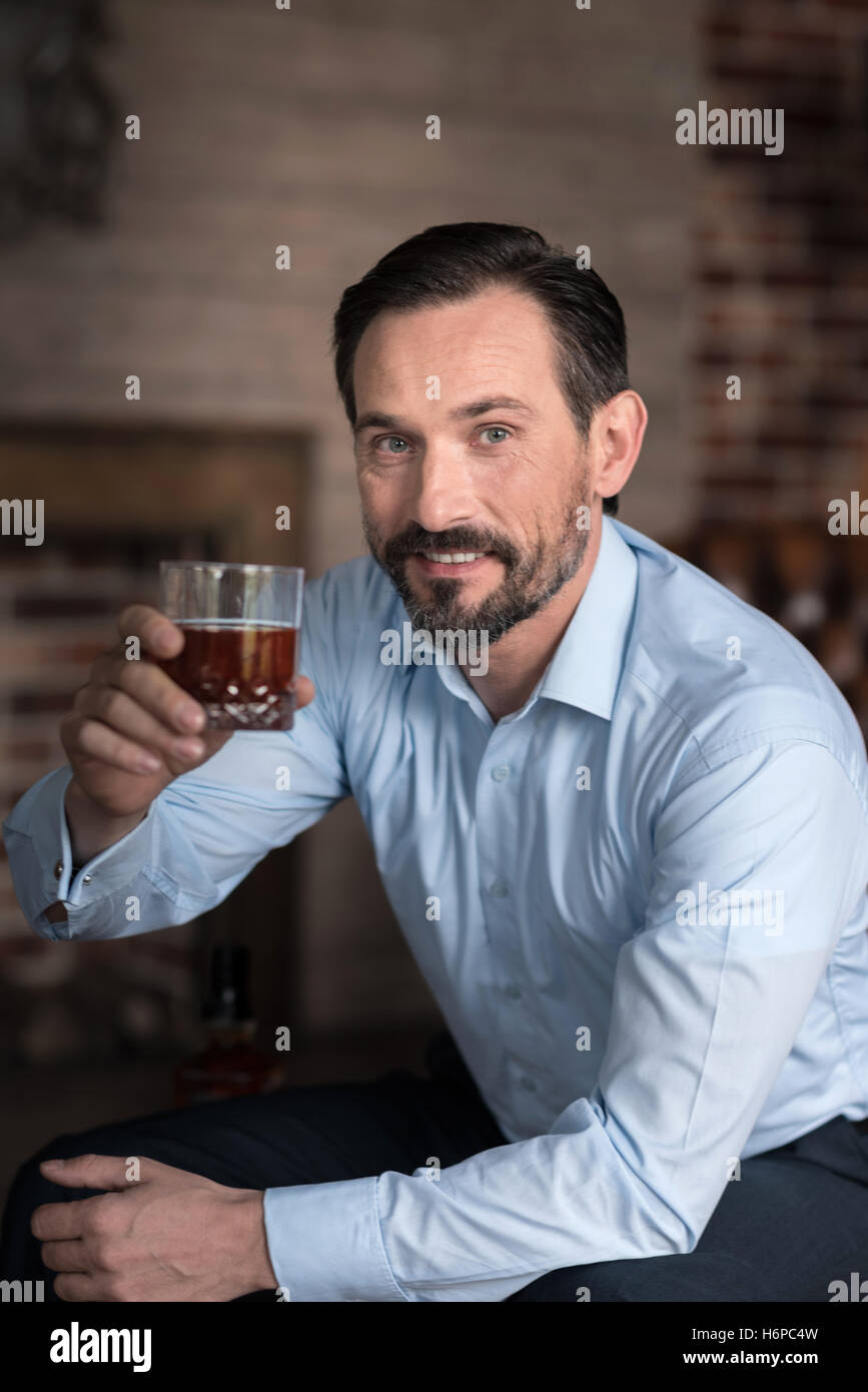 Schöne glücklicher Mann hält seine Hand mit einem Glas Stockfoto