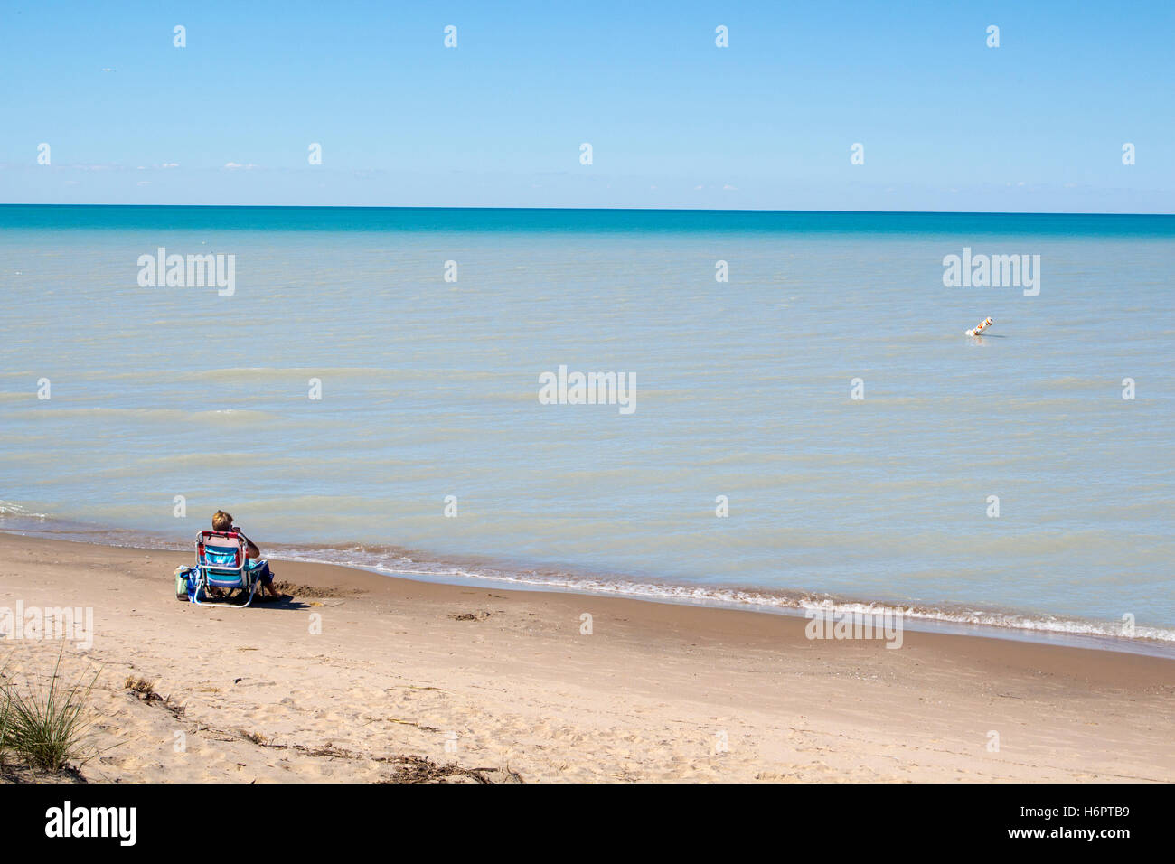 Mann am Strand mit Handy Lokoing, Lake Huron und Sandbänke Stockfoto