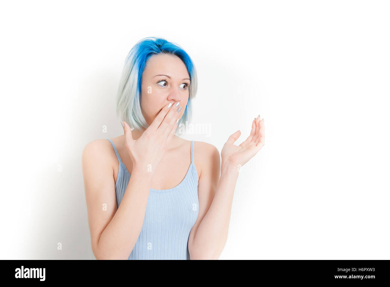 Junge Teen Hipster Frau Porträt, Hand am Mund, erstaunt und überrascht, betrachtet man ihre linke Seite isoliert auf weißem Hintergrund Stockfoto