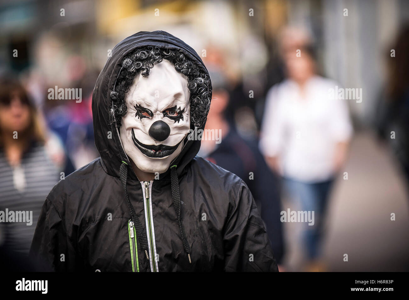 Ein Teenager mit einer Clownsmaske während Halloween feiern. Stockfoto