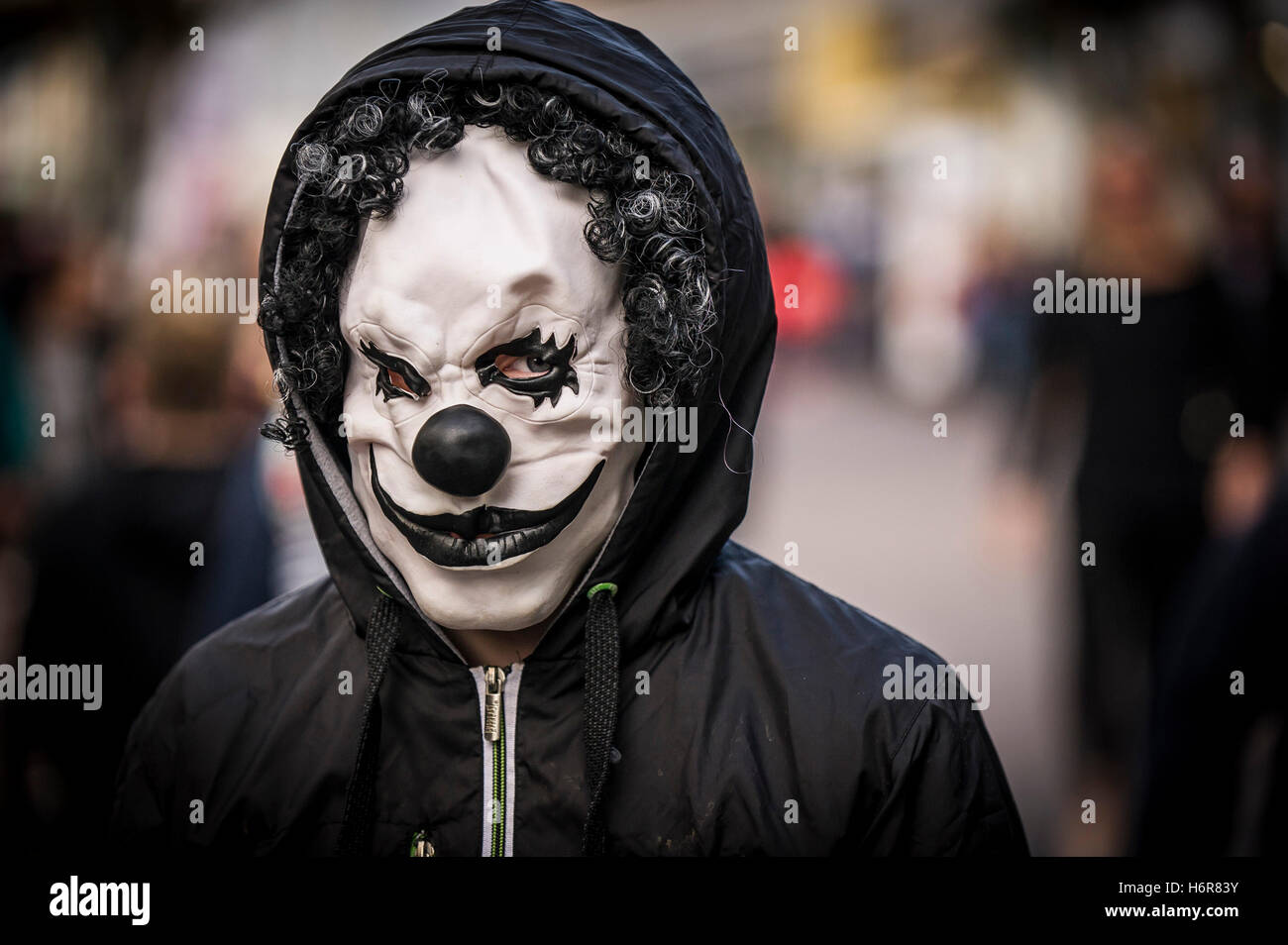Ein Teenager mit einer Clownsmaske während Halloween feiern. Stockfoto