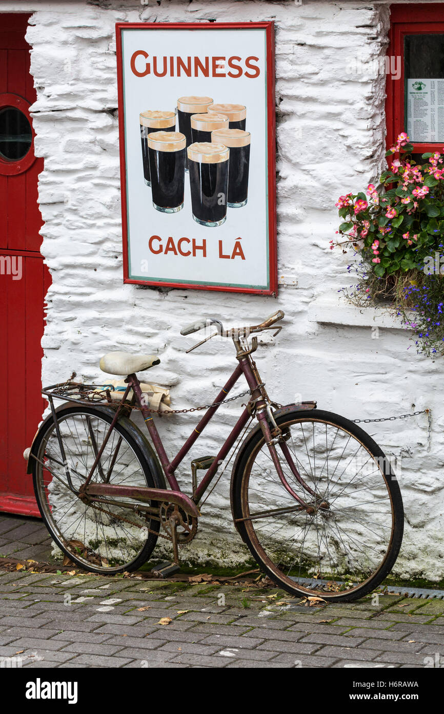 Altes Fahrrad und Guinnes Werbung außen An Lehren Beag, kleines Haus, Pub in der Union Halle, Glandore, County Cork, Irland Stockfoto