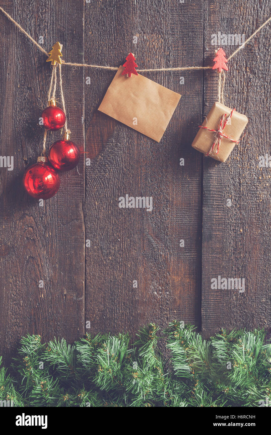 Weihnachtsgirlande mit Spielzeug und Geschenke auf einem dunklen Hintergrund aus Holz. Stockfoto