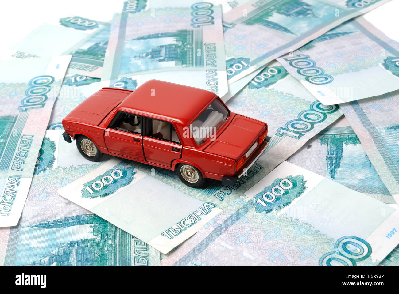 Spielzeugauto auf dem Hintergrund der Banknoten. Stockfoto