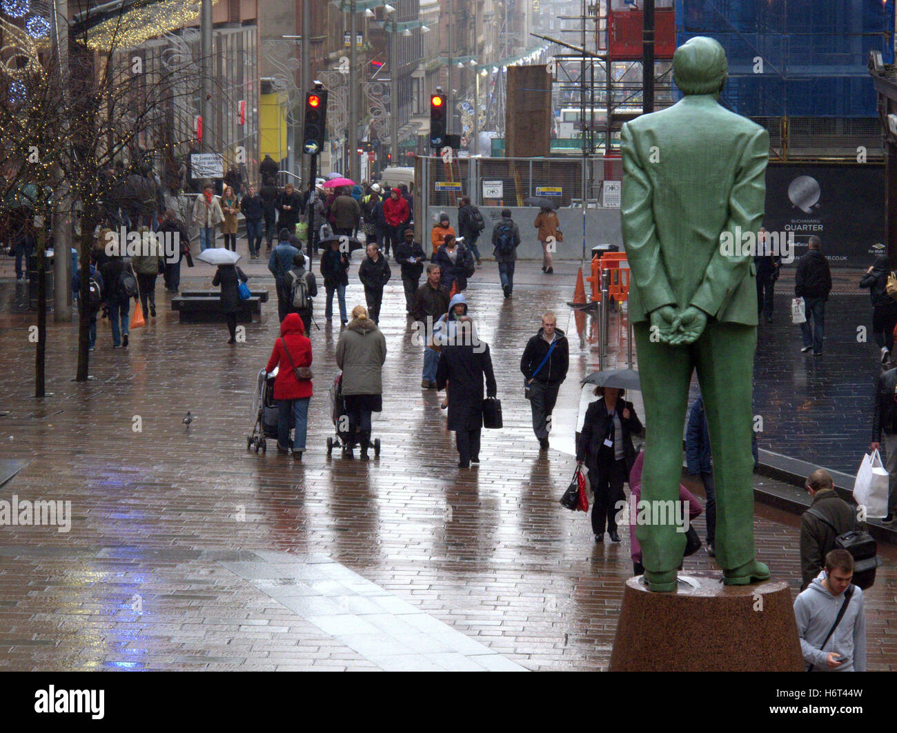 Glasgow in den Regen nassen Straßen und Sonnenschirm Sonnenschirme Einkaufstaschen Stockfoto