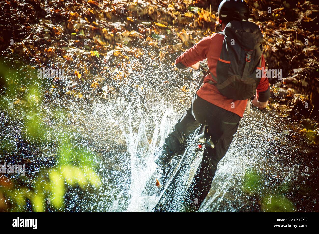 High Speed Bike Ride Bergfluss Kreuzung mit riesigen Spritzwasser. Extreme Mountainbike-Touren Stockfoto