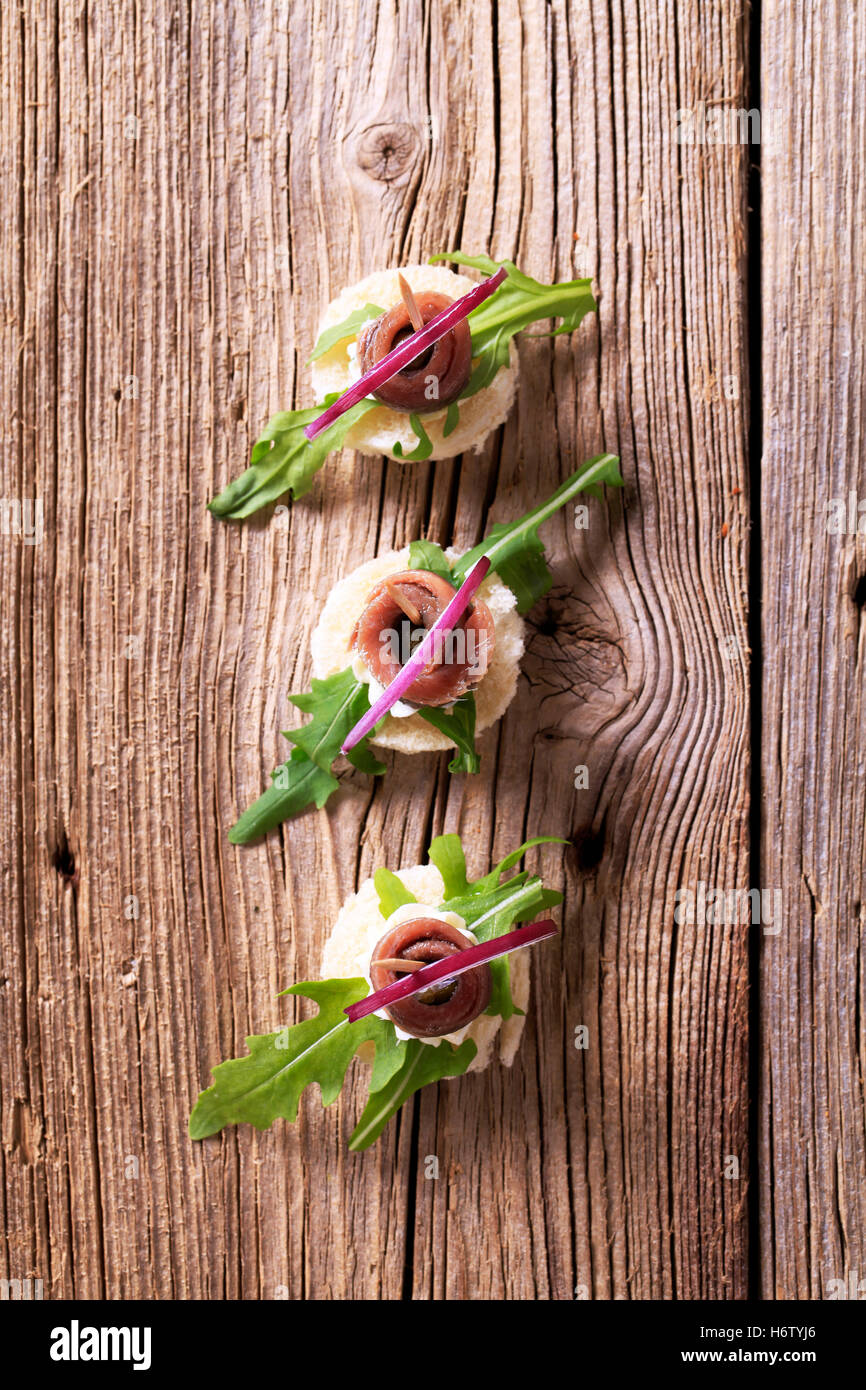 Lebensmittel Nahrungsmittel Brot Closeup Holz Winkel Fisch roh Gourmet-Rakete gerollt niemand rustikal rustikal behandeln Vorspeise Beilage gesalzen Stockfoto