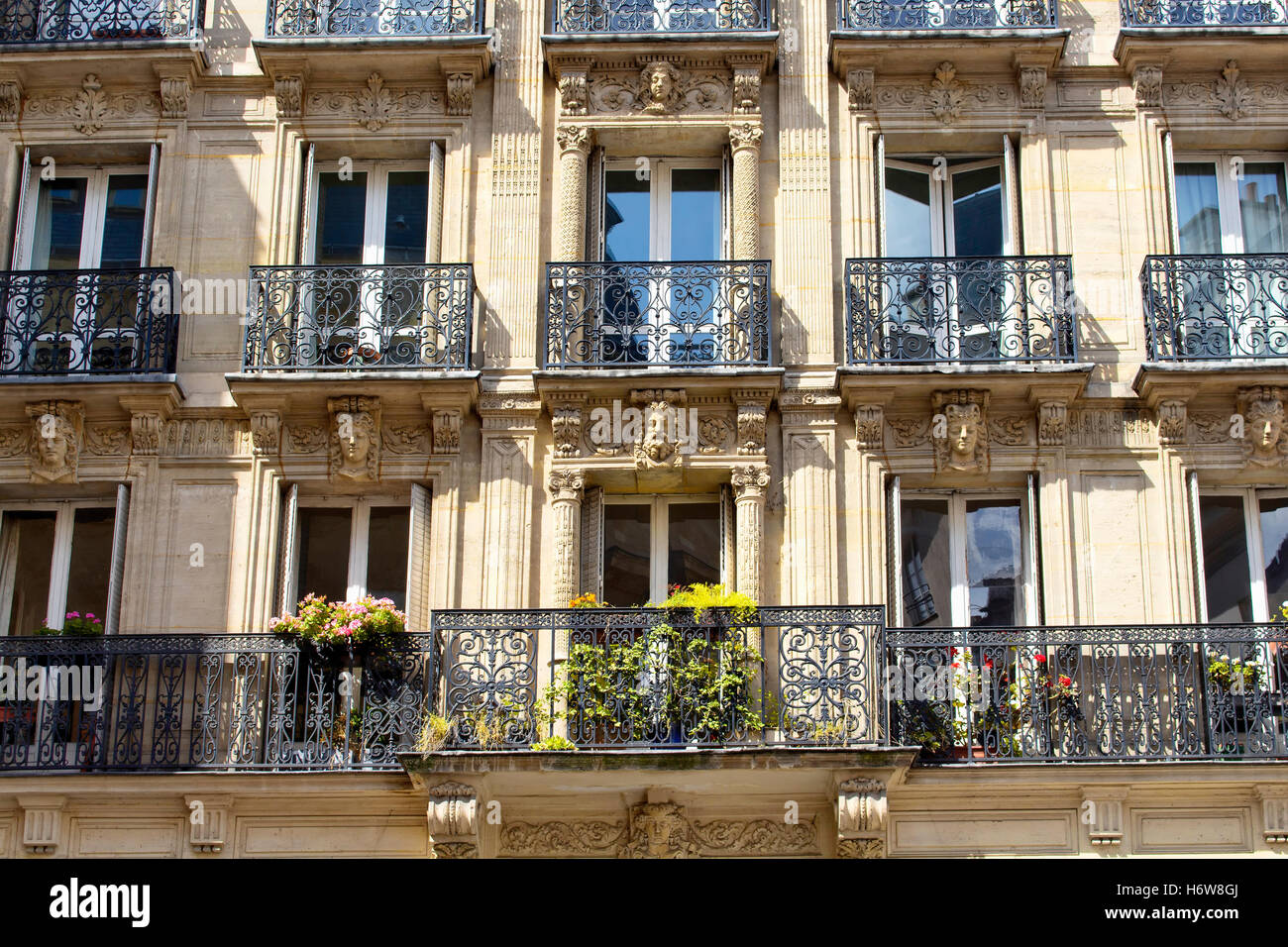 Blick auf ein traditionelles Gebäude in Paris mit französischen Baustil. Schnitzereien und Eisen zu arbeiten, einen Balkon und einige Blumen-cr Stockfoto