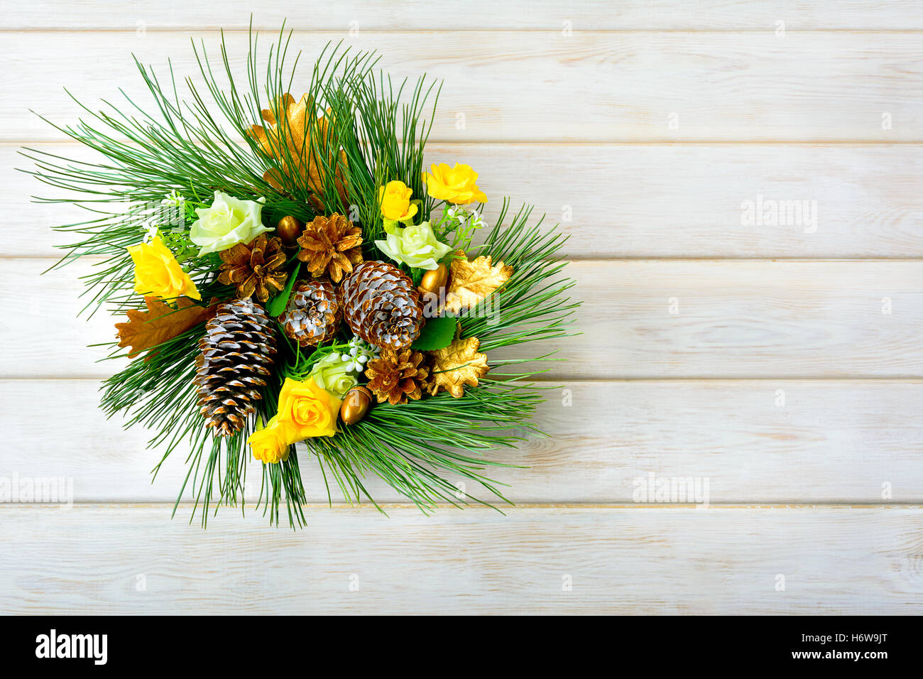 Adventskranz mit gelber Seide Rosen und goldenen Tannenzapfen. Weihnachts-Party-Dekoration. Weihnachten Gruß Hintergrund. Stockfoto