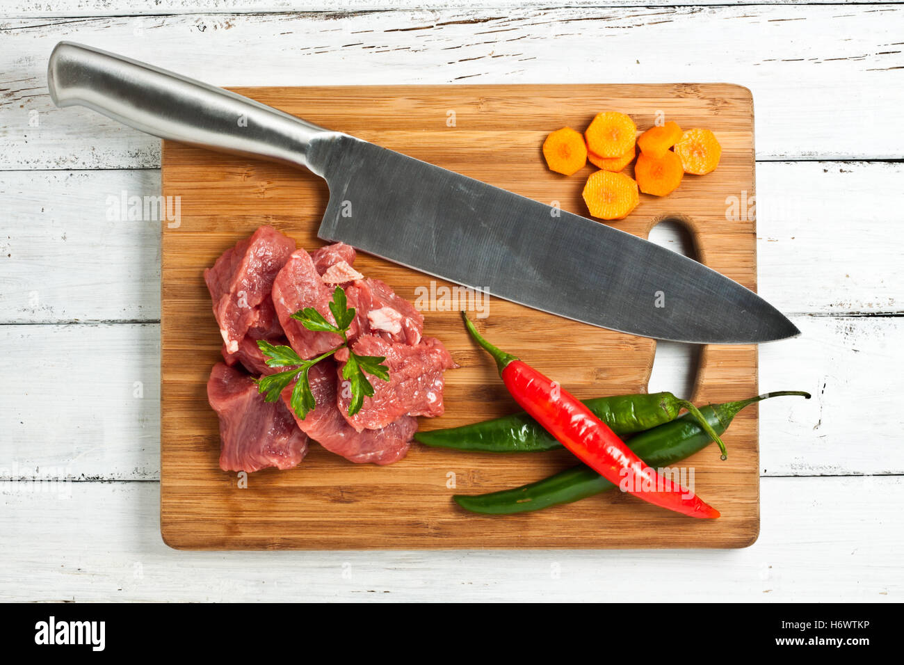 rohes gehackte Fleisch Hackfleisch gehackte Lebensmittel Nahrungsmittel grüne rohe Möhre Metzger Eintopf Chili Chili Fleisch Stücke Arm Waffe Messer Kochmesser Stockfoto