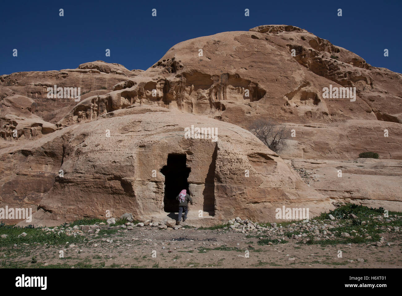 Ein Beduine in einem Felsen geschnitten Höhle am al Beidha oder Bayda eine jungsteinzeitliche archäologische Stätte wenige Kilometer nördlich von Petra in der Nähe von Siq al-Barid in Jordanien Stockfoto