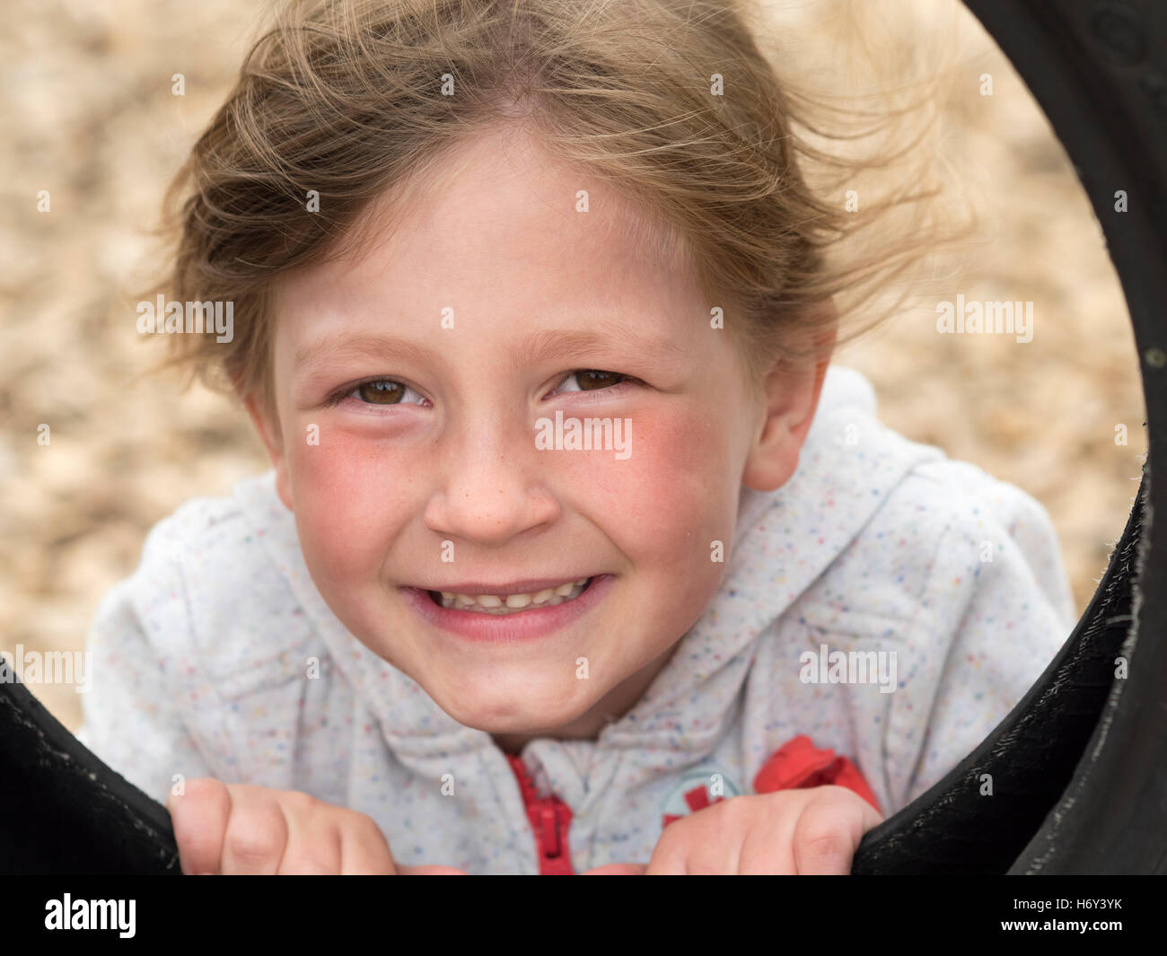 Junge 6 Jahre altes Mädchen spielen und posieren auf einem Spielplatz. Stockfoto