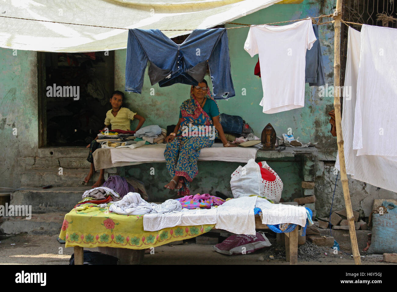 Varanasi, Indien - ca. Juli 2008: Zwei nicht identifizierte Hindu-Frauen ausruhen vor einem improvisierten Wäscherei / ein Teil des Hauses Stockfoto