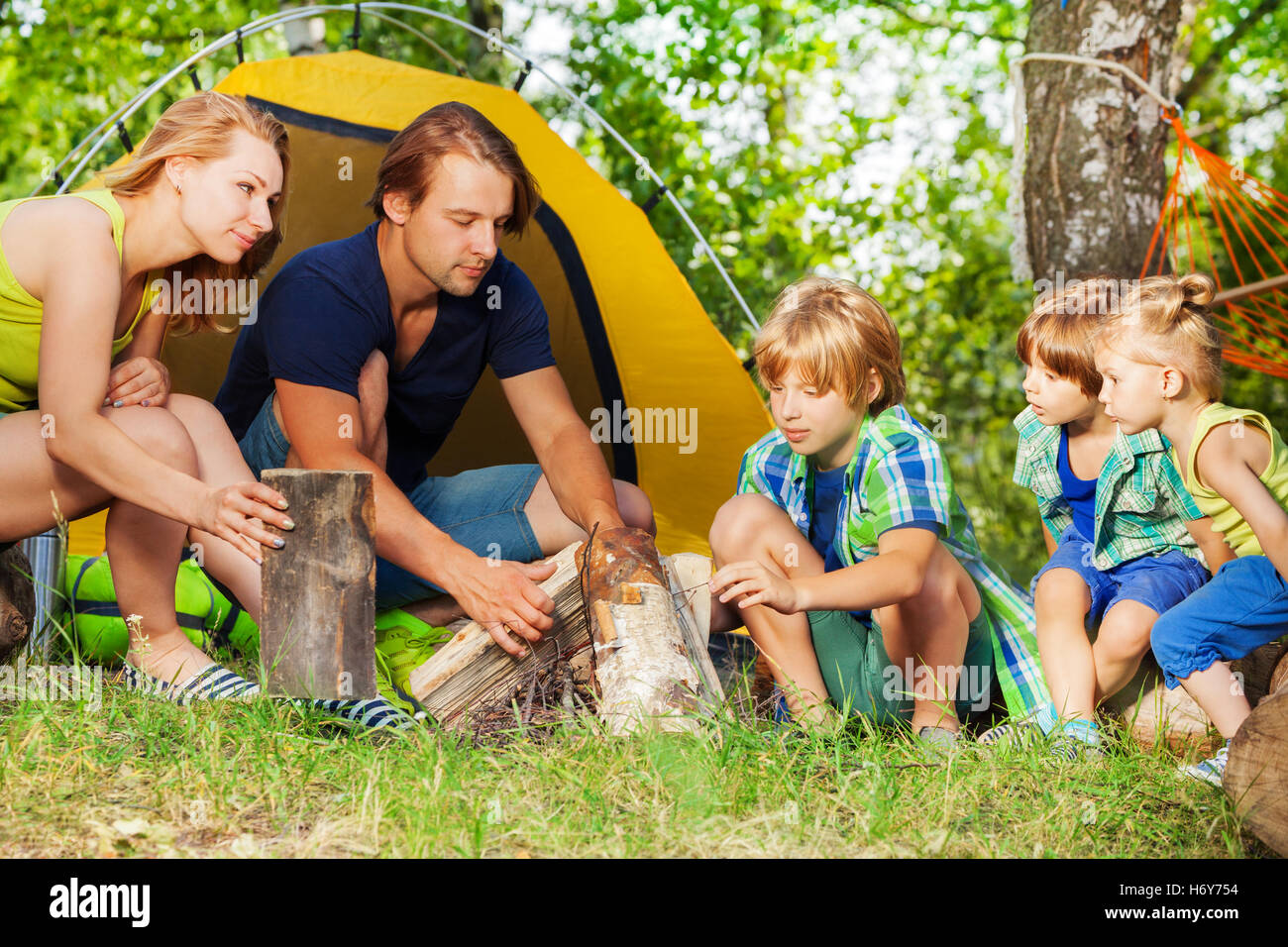 Junge aktive Familie machen Lagerfeuer im Wald Stockfoto