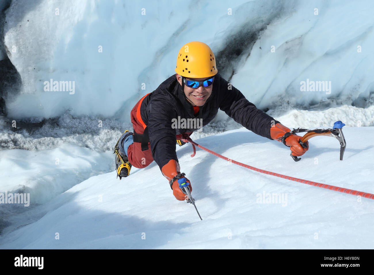 Eiskletterer hält um für die Kamera zu Lächeln, als er aus einer Gletscherspalte auf dem Matanuska Gletscher, Alaska Klettern ist. Stockfoto