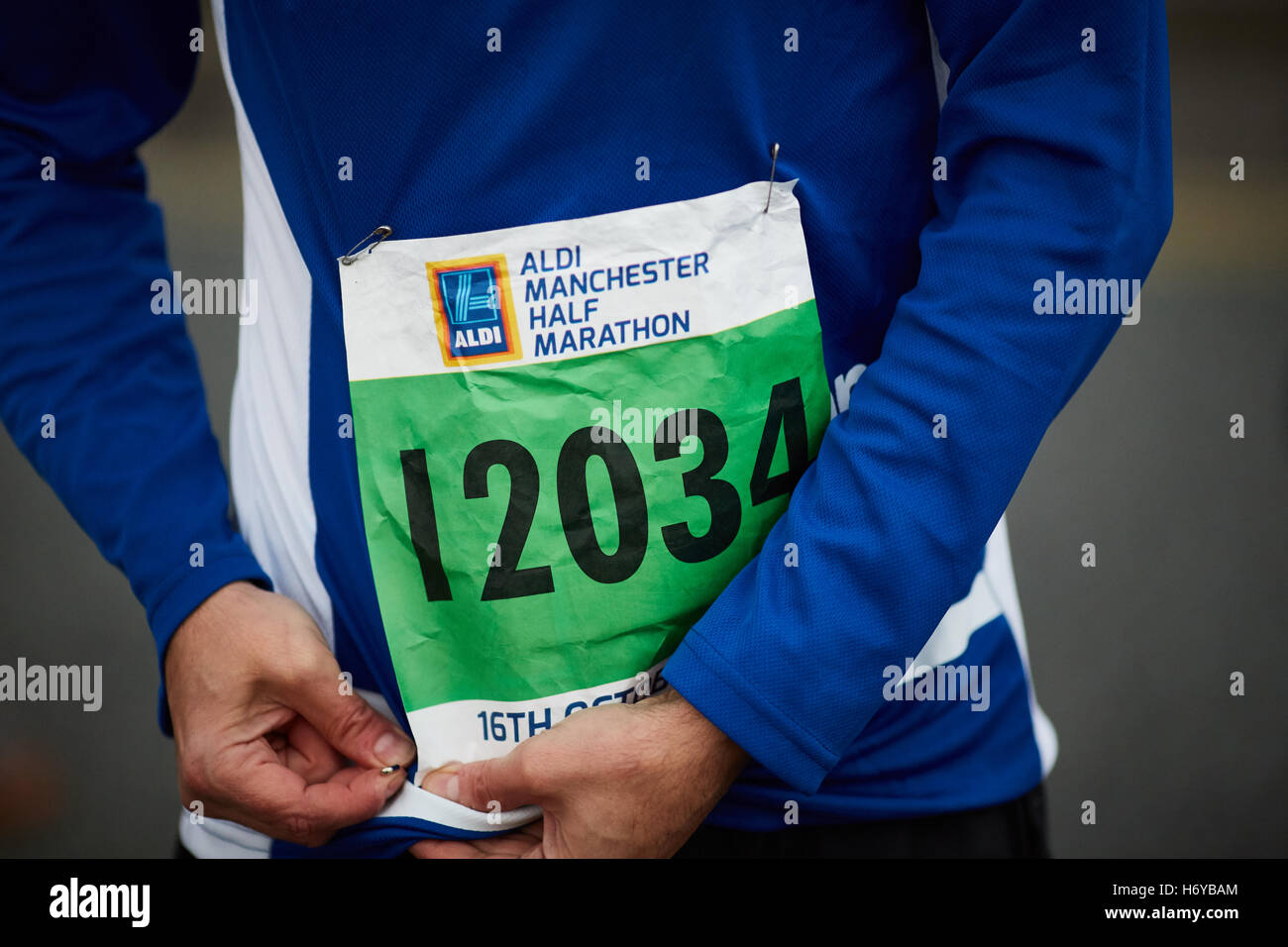 Marathon-Läufer Befestigung Nummer Lätzchen Stifte Aldi gesponserten Veranstaltung Mann männlichen Vater Papa Laufwettbewerb über die Ziellinie Stockfoto