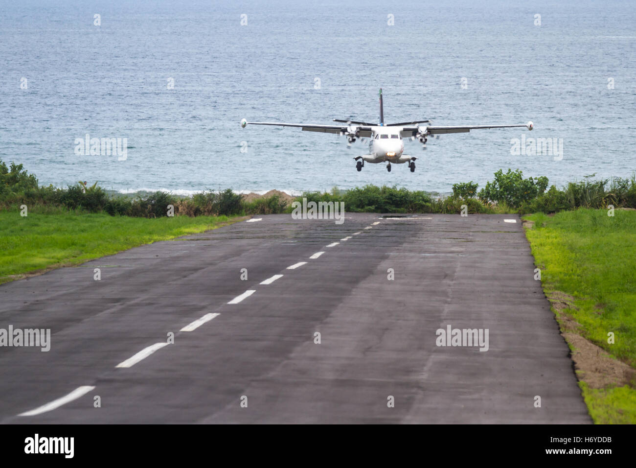 kleine lokale Flug Landung auf eine kleine asphaltierte Start-und Landebahn mit dem Pazifischen Ozean im Hintergrund in Costa Rica Stockfoto