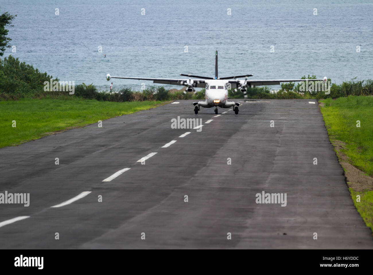 kleine lokale Flug Landung auf eine kleine asphaltierte Start-und Landebahn mit dem Pazifischen Ozean im Hintergrund in Costa Rica Stockfoto