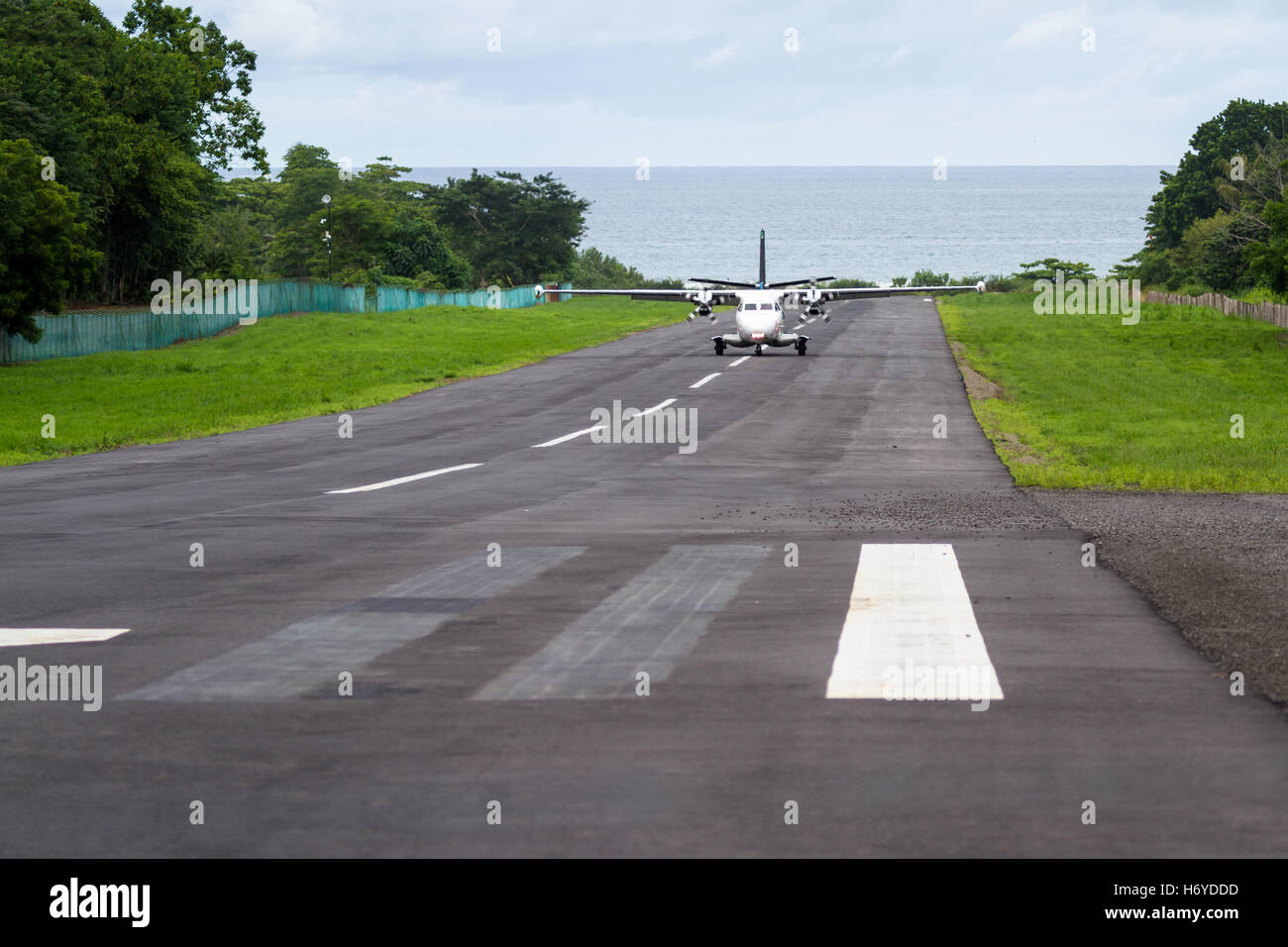 kleine lokale Flug Landung auf eine kleine asphaltierte Start-und Landebahn mit dem Pazifischen Ozean im Hintergrund in Costa Rica Stockfoto