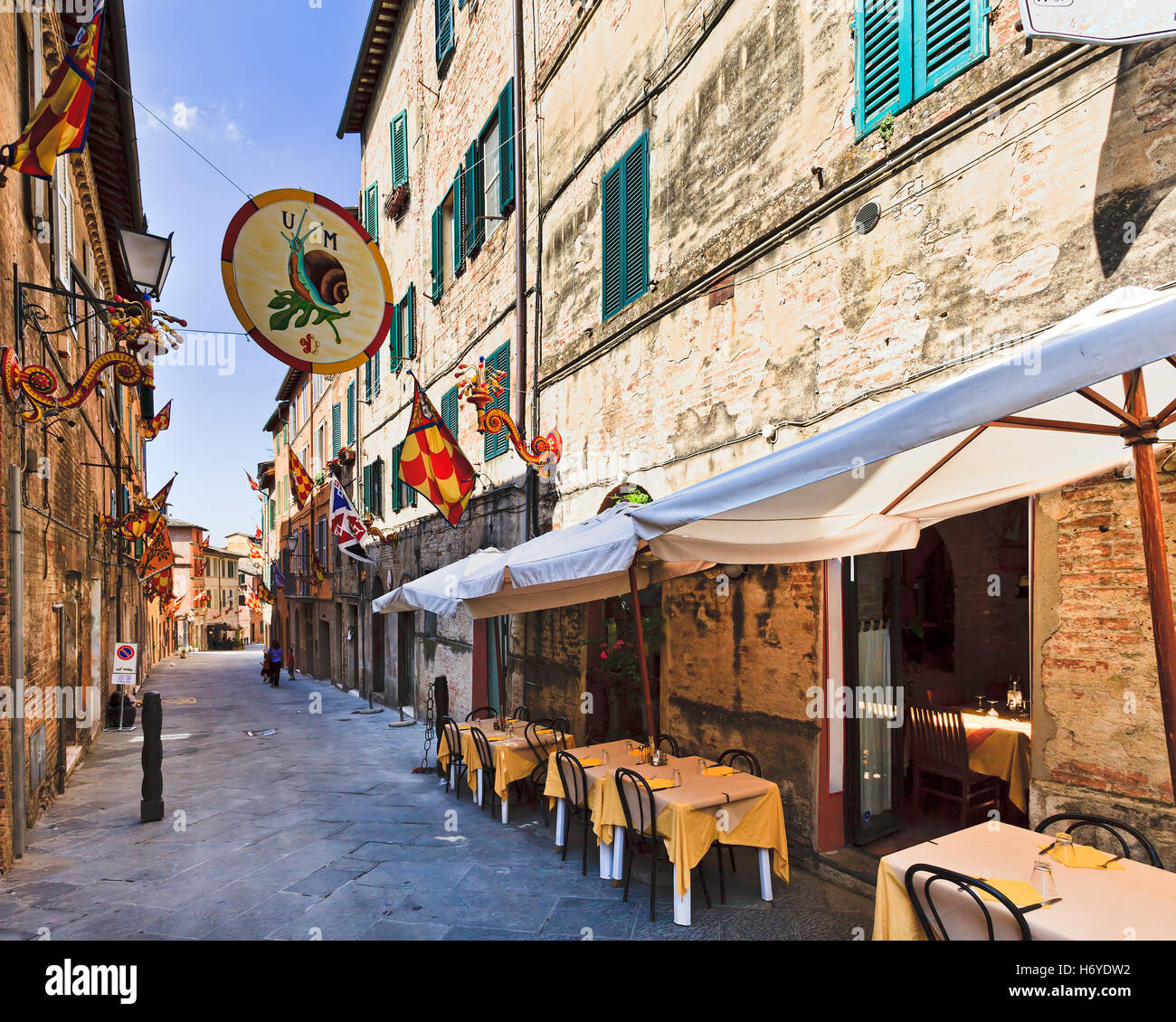 touristische Fußgängerzone im historischen Stadtzentrum von Siena an einem sonnigen Tag mit Cafés und Dienstleistungen Waiiting für Kunden geöffnet Stockfoto