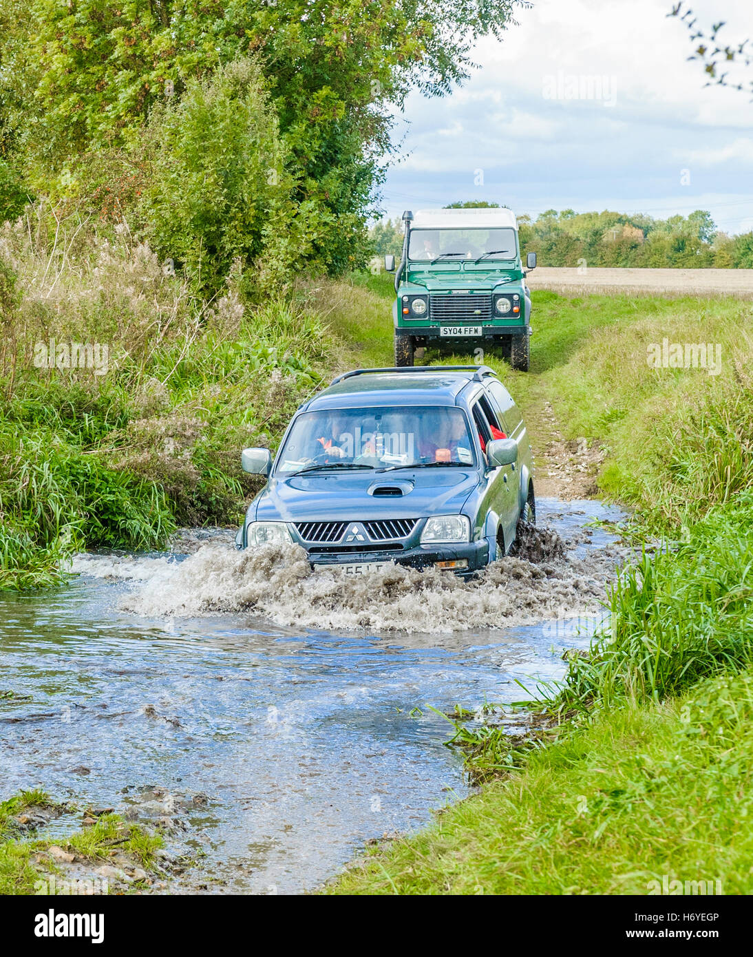 Ein 4 x 4 und einem Landrover Defender 90 überqueren oder fording, einem Bach oder Fluss Stockfoto