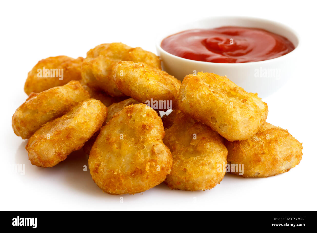 Haufen von golden frittierte angeschlagenen Hähnchen-Nuggets mit Schüssel Ketchup, isoliert auf weiss. Stockfoto