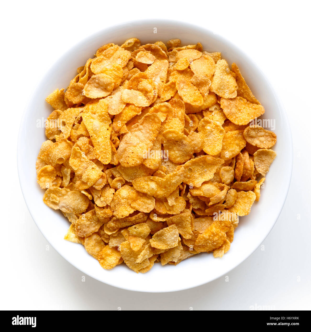 Schale mit trockenen Cornflakes isoliert auf weiss von oben Stockfotografie