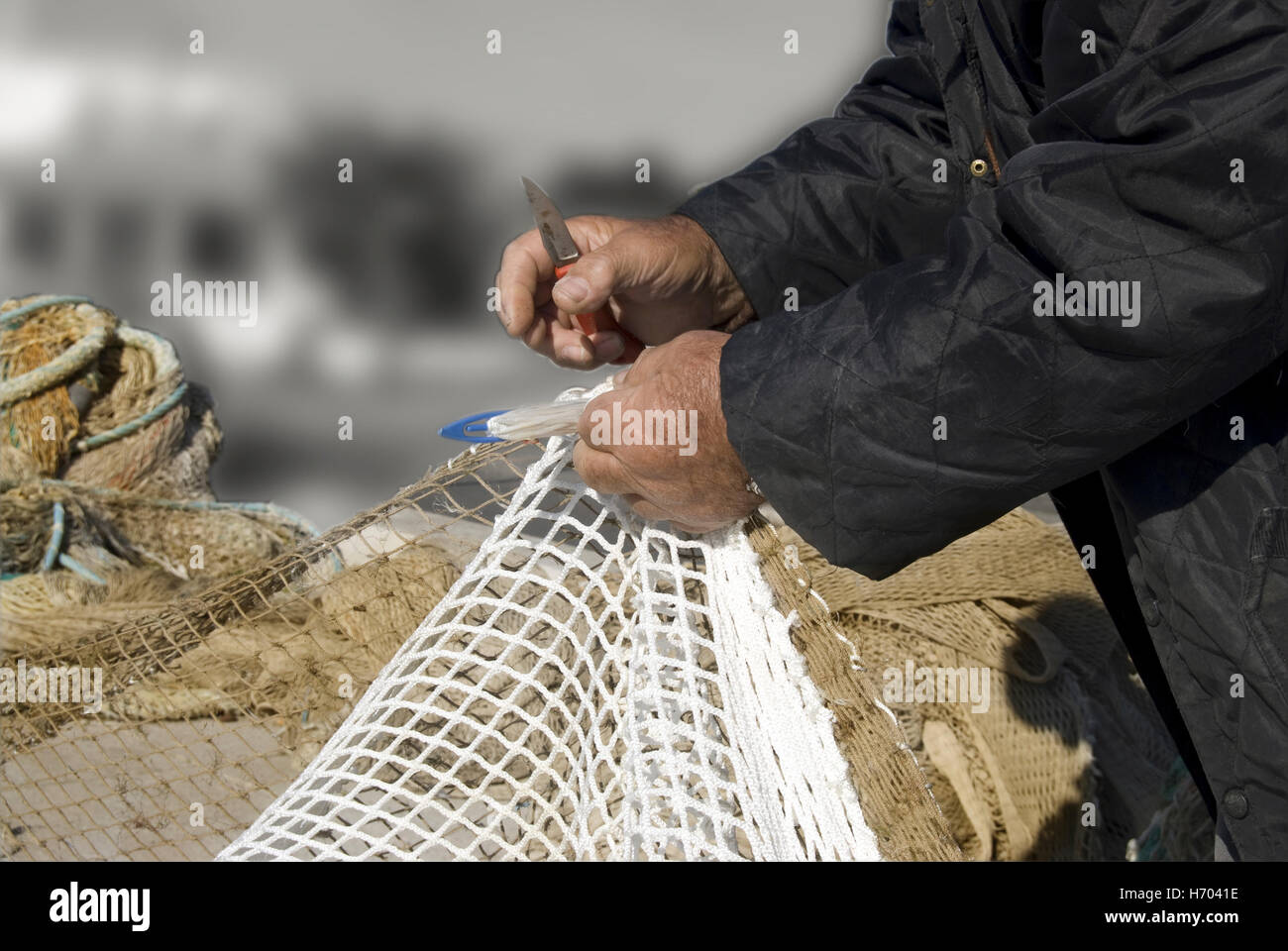 Nahaufnahme der Hände eines Fischers Reparatur ein Netz Stockfoto