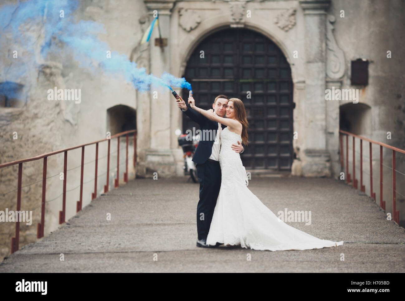 Die Braut und Bräutigam mit Rauchbomben auf dem Hintergrund der Burg Stockfoto
