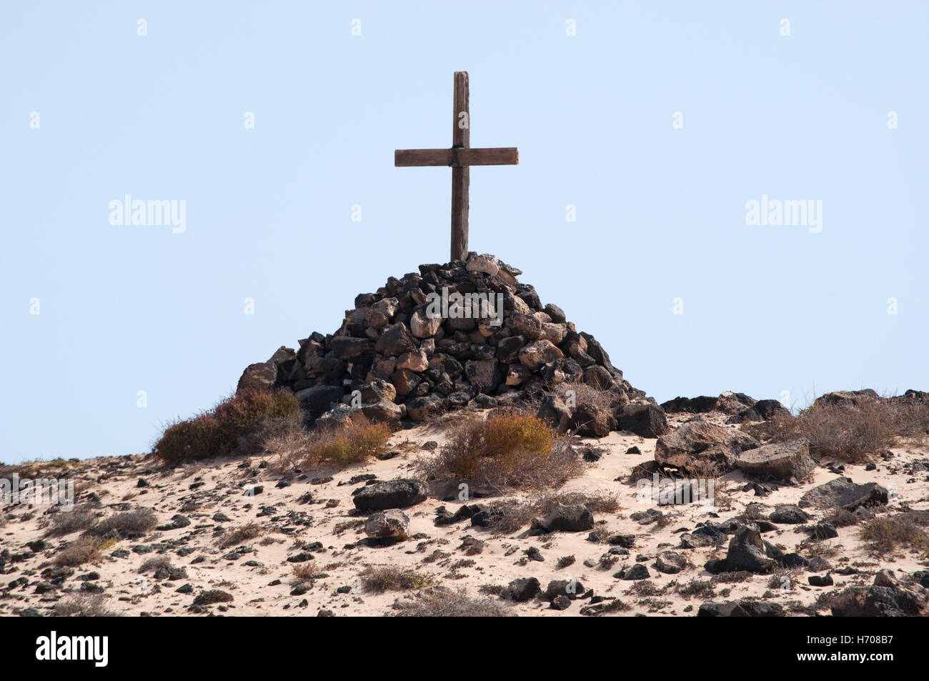 Fuerteventura, Kanarische Inseln, Nordafrika, Spanien: ein Grab mit einem Haufen von Steinen und einem Holzkreuz in der Wüste Landschaft in der Nähe von El Cotillo Stadt Stockfoto