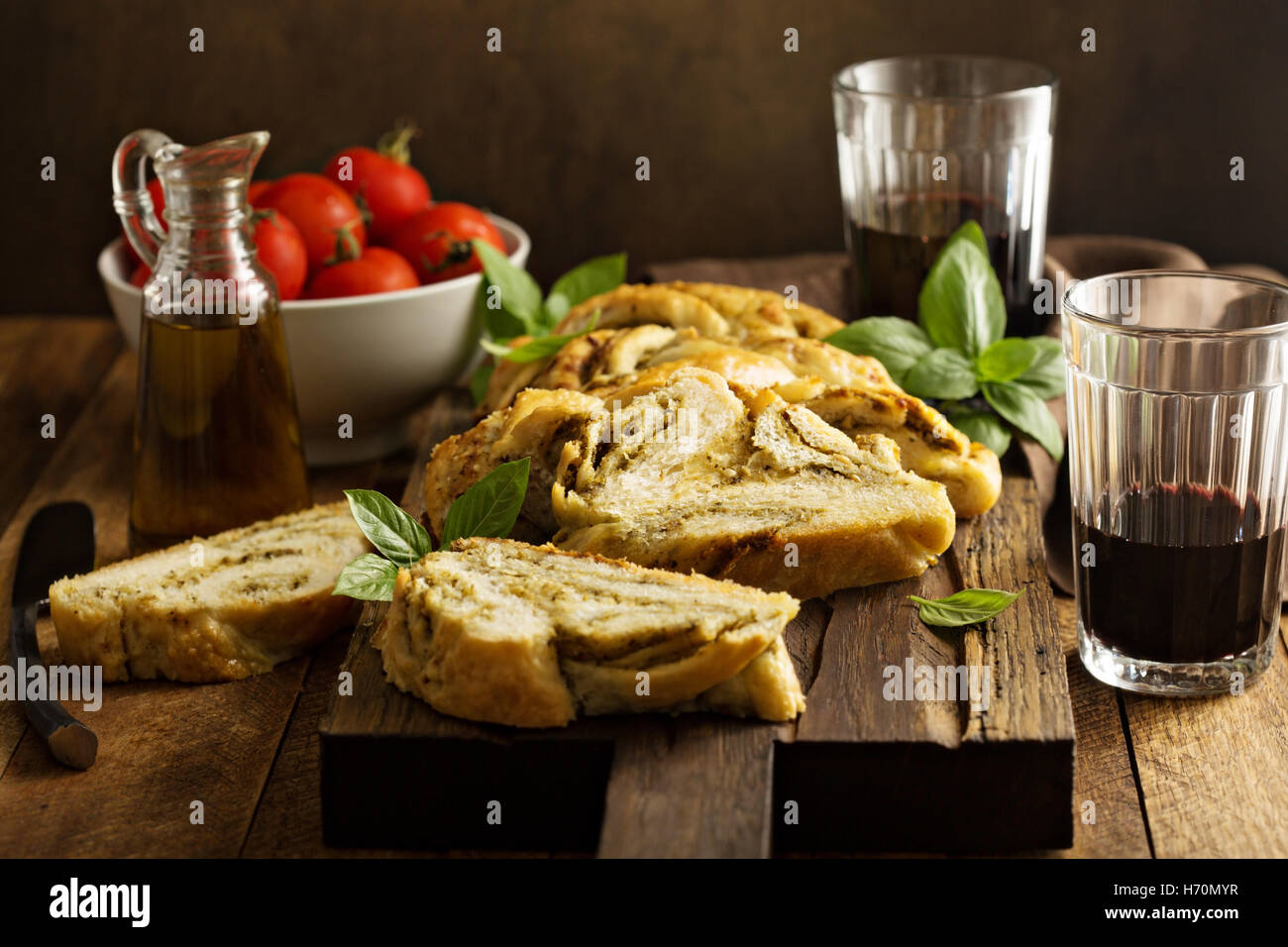 Hausgemachte geflochtene Basilikum Pesto Brot in Scheiben geschnitten auf einem Schneidebrett Stockfoto