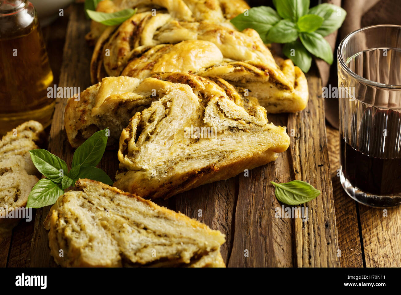Hausgemachte geflochtene Basilikum Pesto Brot in Scheiben geschnitten auf einem Schneidebrett Stockfoto