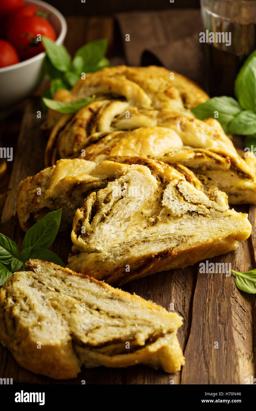 Hausgemachte geflochtene Basilikum Pesto Brot in Scheiben geschnitten auf einem Schneidebrett Stockfoto
