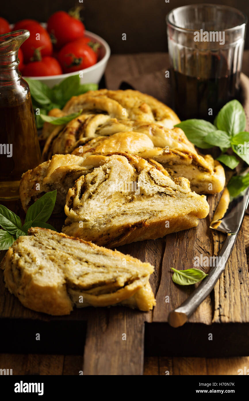Hausgemachte geflochtene Basilikum Pesto Brot in Scheiben geschnitten auf einem Schneidebrett Stockfoto