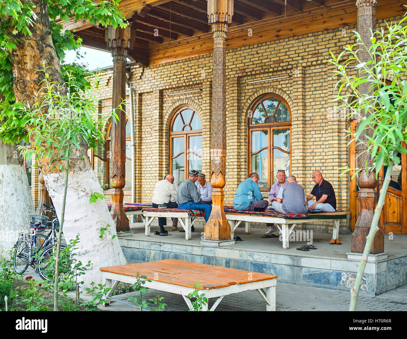 Die Einheimischen genießen Sie die schattige Terrasse des Teehauses Stockfoto