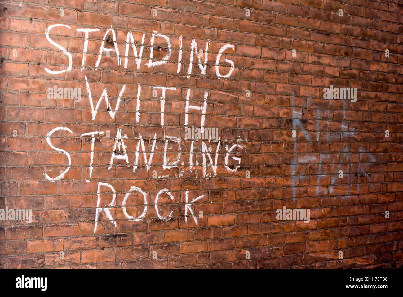 Stehend mit Standing Rock geschrieben an der Wand in einer Gasse in Brattleboro, VT. Stockfoto