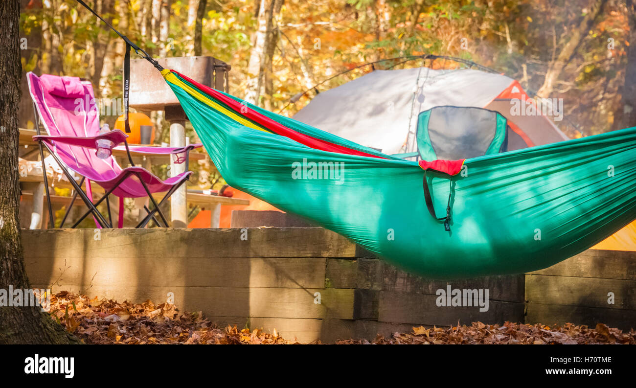 Ein Wohnmobil schläft in einer hängenden Hängematte als am Morgen, die Sonne über dem Campingplatz am Vogel State Park in der Nähe von Blairsville, GA. geht Stockfoto