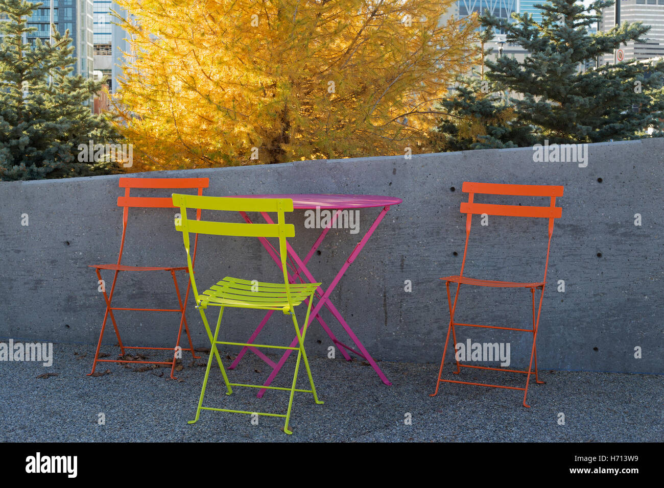 Farbenfrohe Stühle und Tisch auf der Terrasse im Freien in East Village, Calgary, Alberta, Kanada Stockfoto